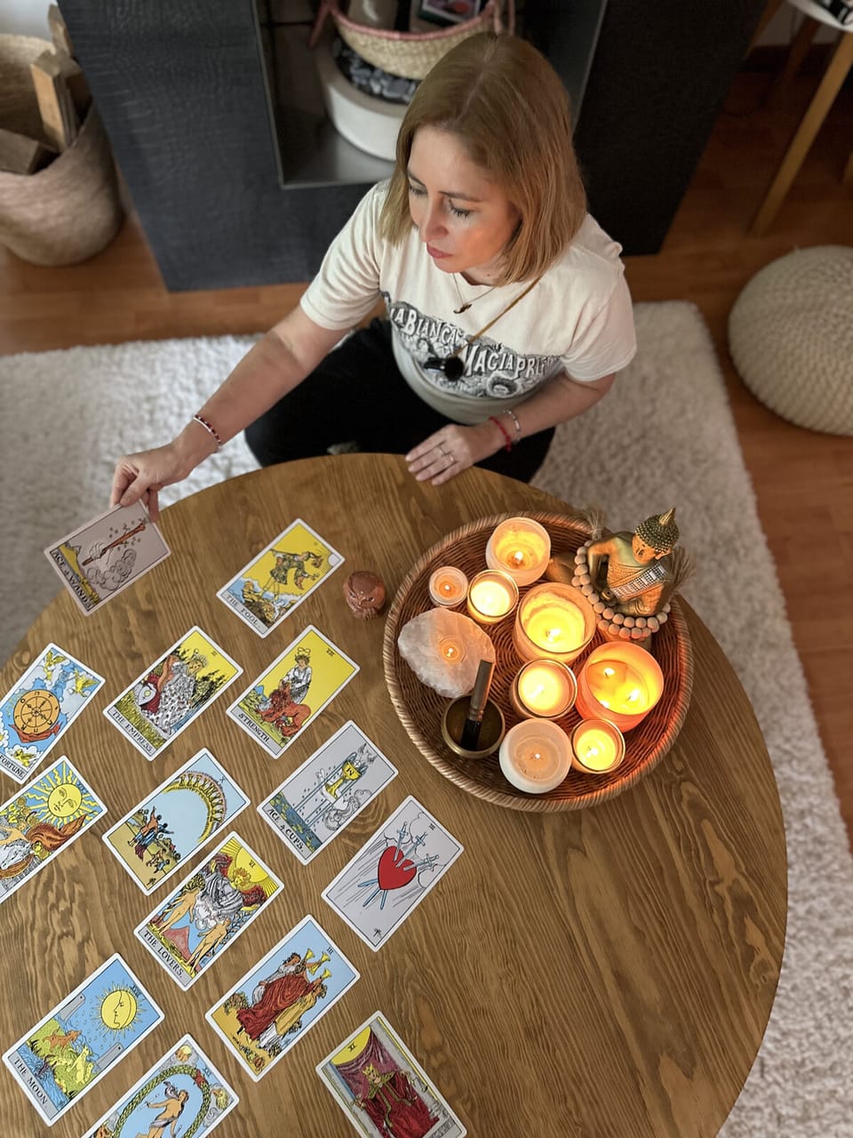 Vista cenital de una lectura de tarot con cartas y velas encendidas